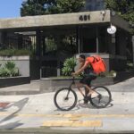 Um entregador de Ifood sobre uma bicicleta pedalando na calçada no Largo da Batata, em São Paulo. Fotografia realizada no contexto de um projeto educacional na Faculdade Cásper Líbero, em 2021 Foto: Laura Monteiro Fernandes / Wikimedia Commons / CC BY-SA 4.0