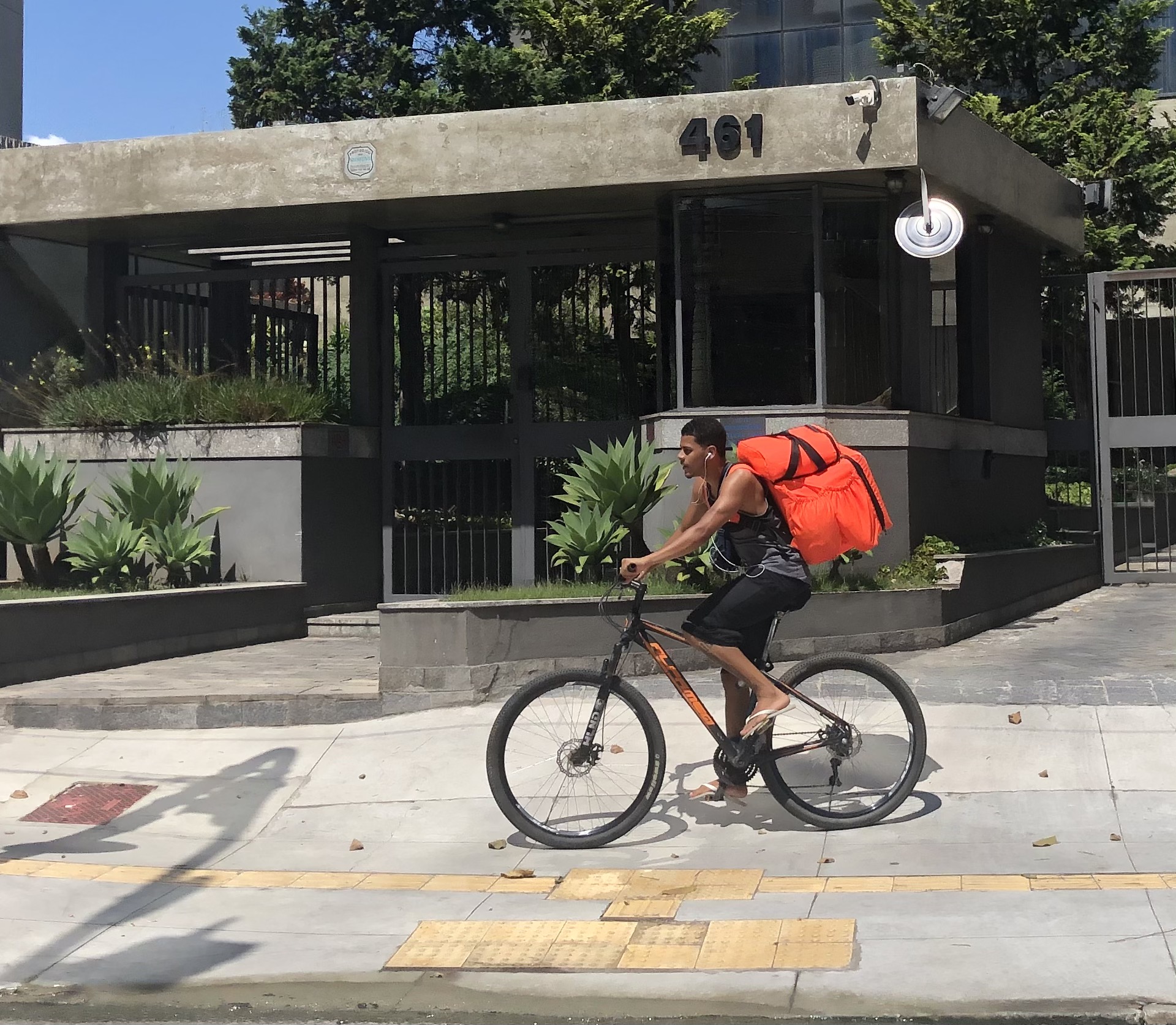 Um entregador de Ifood sobre uma bicicleta pedalando na calçada no Largo da Batata, em São Paulo. Fotografia realizada no contexto de um projeto educacional na Faculdade Cásper Líbero, em 2021 Foto: Laura Monteiro Fernandes / Wikimedia Commons / CC BY-SA 4.0