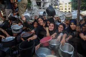 Fome e desnutrição na Palestina. GAZA, 15 de julho de 2025 (Xinhua) -- Palestinos deslocados aguardam para receber comida gratuita em um centro de distribuição de alimentos na Cidade de Gaza, em 14 de julho de 2025. (Foto de Rizek Abdeljawad/Xinhua)