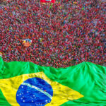Multidão com bandeira do Brasil durante a posse de Lula para o terceiro presidencial. Brasília, 01/01/2023. Foto: Ricardo Stuckert / PR