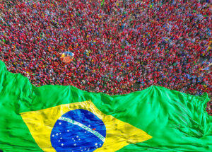 Multidão com bandeira do Brasil durante a posse de Lula para o terceiro presidencial. Brasília, 01/01/2023. Foto: Ricardo Stuckert / PR