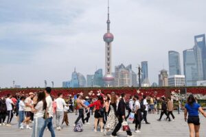 Turistas caminham pelo Bund, em Xangai, no leste da China, com vista para o distrito financeiro de Pudong ao fundo, em 30/04/2023. Crédito: Xinhua / Xin Mengchen