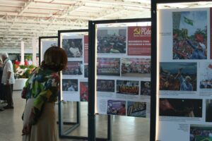 Visitantes observam painéis da exposição “103 anos de lutas do PCdoB”, que reúne imagens e textos sobre a trajetória do partido e suas conquistas recentes. Foto: J.lee Aguiar