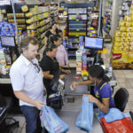 Trabalhadora do Supermercado São Luiz, em Planaltina, Distrito Federal, atende consumidores em supermercado, com prateleiras e produtos ao fundo. Foto: Edilson Rodrigues/Agência Senado