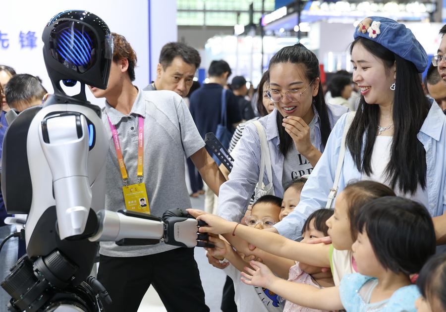 (250907) -- CHONGQING, Sept. 7, 2025 (Xinhua) -- Visitors interact with a home service robot during the World Smart Industry Expo 2025 in southwest China's Chongqing Municipality, Sept. 6, 2025. The World Smart Industry Expo 2025 kicked off on Friday in southwest China's Chongqing Municipality, showcasing advanced achievements including AI rehabilitation systems, portable wearable devices, elderly care robots, and senior-friendly equipment. (Xinhua/Chen Cheng)